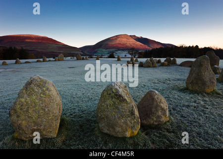 Castlerigg Stone Circle an einem frostigen Morgen, während die ersten Sonnenstrahlen die Piste von Blencathra im Lake District. Stockfoto