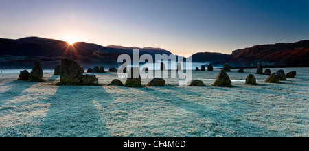 Der Castlerigg Stone Circle an einem frostigen Morgen als die ersten Sonnenstrahlen erscheinen über die Berge im Lake District. Stockfoto
