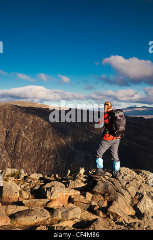 Eine junge Frau auf dem Gipfel eines Berges im Lake District. Stockfoto