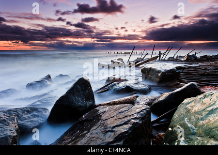Morgendämmerung über zerstörten Meer Abwehrkräfte bei Happisburgh auf Norfolk Nordseeküste. Stockfoto