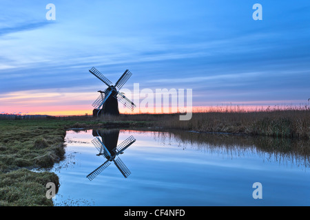 Herringfleet Kittel Mühle an einem nebligen Wintermorgen in stillem Wasser reflektiert. Stockfoto