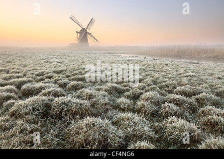 Blick über frostigen Boden Herringfleet Kittel Mühle im Nebel an einem Wintermorgen. Stockfoto