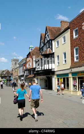 Ein junges Paar hand in hand gehen, entlang der Fußgängerzone High Street in Salisbury. Stockfoto