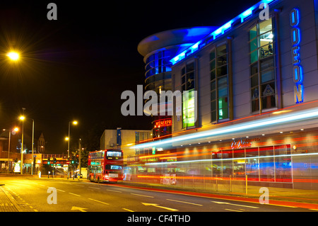 Lichtspuren von einem Doppeldecker-Bus außerhalb der Rotunde Shopping Centre in der Nacht. Stockfoto