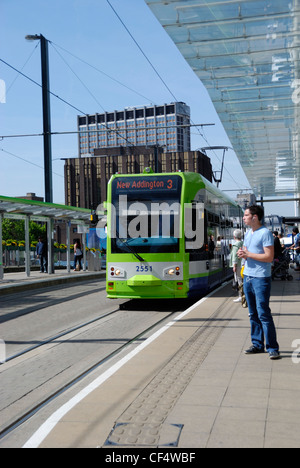 Ein Mann steht auf einer Plattform warten auf eine Straßenbahn auf Croydon Tramlink-Bahnhof East Croydon. Stockfoto