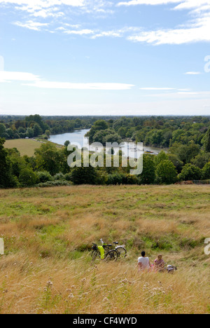 Ein paar, eine Pause von ihrem Zyklus fahren, genießen den Blick auf die Themse, Richmond Hill. Stockfoto