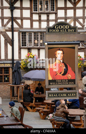 Menschen sitzen außerhalb der alten Wellington Inn in New Cathedral Gate. Das Gebäude, das seit 1552 ist die älteste in Stockfoto