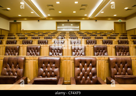 Konferenzräume mit herrlichen Ledersesseln und Holztische mit Mikrofonen Stockfoto