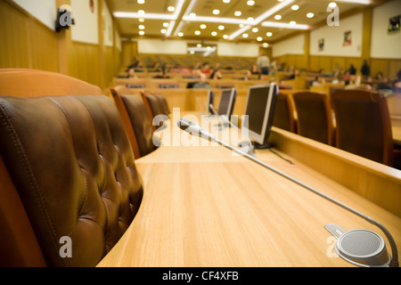 Konferenzräume mit herrlichen Ledersesseln und Holztische mit Mikrofone und Monitore, Nahaufnahme Stockfoto