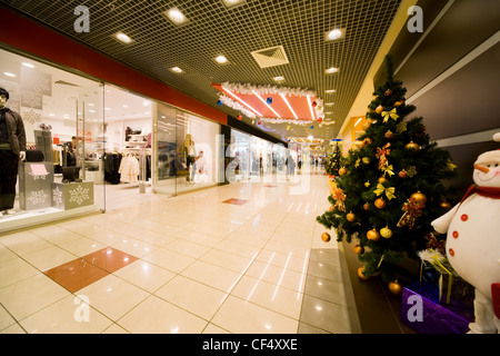 Tanne dicht bewachsen von Weihnachtsschmuck im Einkaufszentrum Flur in der Nähe Kleidung shop Stockfoto