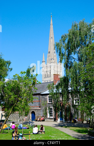 Der Turm der Norwich Kathedrale mit Blick auf Menschen entspannen im Cathedral Close. Stockfoto