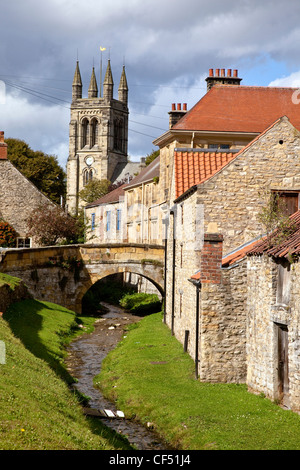 Blick entlang eines Baches in der Markt-Dorf Helmsley in Richtung All Saints Church. Stockfoto