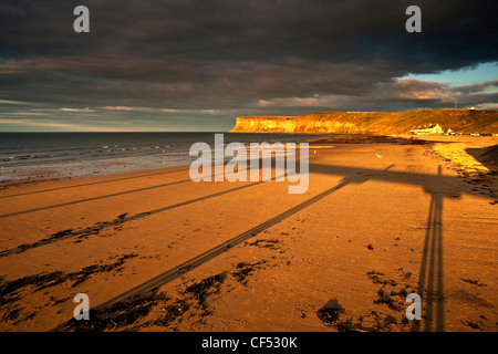 Schatten auf den Strand von den viktorianischen Pier in Saltburn-By-The-Sea, mit Blick auf Huntcliff. Stockfoto