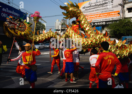 junge Männer in Tracht tragen Dragon Parade feiern lokalen chinesischen Tempel auf New Road erste gepflasterte Straße in der Stadt Thailand Stockfoto