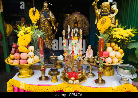 Angebote auf Tisch mit Guanyin Göttin der Barmherzigkeit-Statue im Zentrum feiert lokale Tempel Thailand Bangkok Asien asiatisch Stockfoto