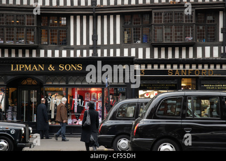 London-Taxis vorbei die gezimmerten tudor Fassade des Staple Inn in Holborn. Stockfoto