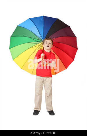 kleiner Junge im roten Hemd öffnete den Mund, mit großen bunten Regenschirm stehen auf weiß Stockfoto