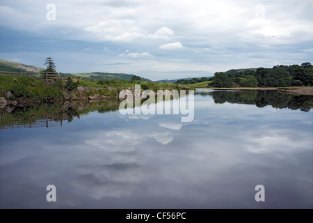 Cumulus-Wolken spiegeln sich in den Fluß Swale, Reeth, Yorkshire, England Stockfoto