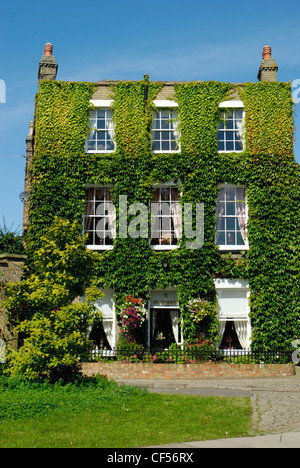 Ein blauer Himmel Hintergrund für den Efeu bedeckt Quay House Hotel in Ely. Stockfoto