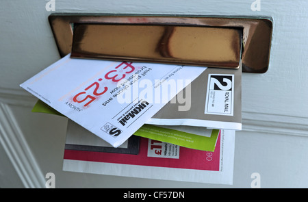 Junk-Mails in einen privaten Heim Briefkasten durch Haustür UK veröffentlicht Stockfoto