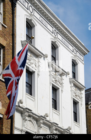 Eine britische Flagge hängt über Gieves und Hawkes Schneider auf Saville Row. Stockfoto