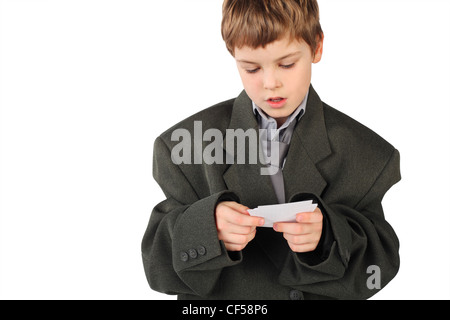 kleiner Junge in großen grauen Herrenanzug Blick auf Visitenkarte isoliert auf weißem Hintergrund Stockfoto
