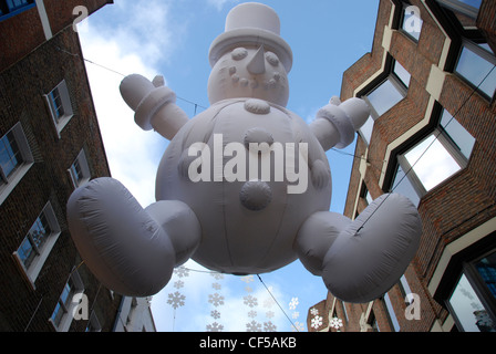 Aufwärts, eine Weihnachts-Dekoration einen riesigen abgehängten Schneemann in der Carnaby Street. Stockfoto