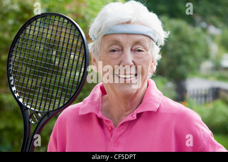 Deutschland, Bayern, Huglfing, Senior Frau mit Badminton-Schläger, Lächeln, Porträt Stockfoto