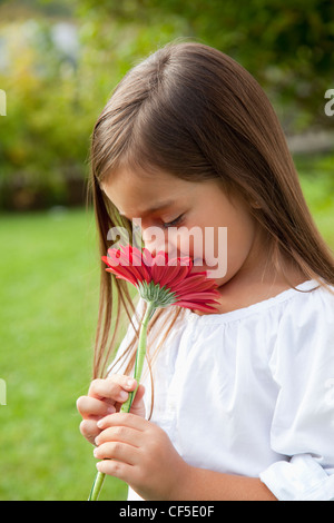 Deutschland, Bayern, Huglfing, Mädchen mit Blume im Garten, Lächeln Stockfoto