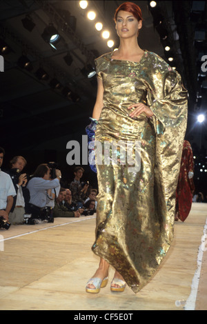 Commes de Garcons Frühling Sommer kanadisches Model Linda Evangelista tragen drapierte gold Kleid und Maultiere Stockfoto