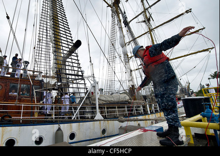 Der US-Navy-Petty Officer 3. Klasse Christopher Maddock hilft, die Linien des indonesischen Navy-Großschiffs KRI Dewaruci abzubinden, als es am 29. Februar 2012 in der Joint Base Pearl Harbor-Hickam, Hawaii ankam. Dewaruci begann ihre Kreuzfahrt von Surabaya, Ost-Java, Indonesien am 14. Januar, im Rahmen der Internationalen Operation Sail (OpSail) 2012 zum Gedenken an den 200. Jahrestag des Krieges von 1812. Stockfoto