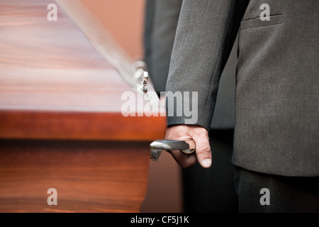 Religion, Tod und Dolor - Sarg Träger tragen die Schatulle bei Beerdigung, Friedhof Stockfoto