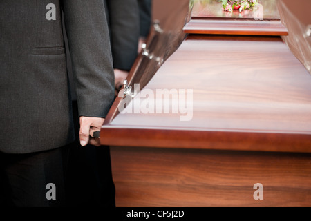 Religion, Tod und Dolor - Sarg Träger tragen die Schatulle bei Beerdigung, Friedhof Stockfoto