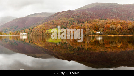 Herbstliche Farben auf die umliegenden Hügel reflektiert in Grasmere See im Lake District. Stockfoto