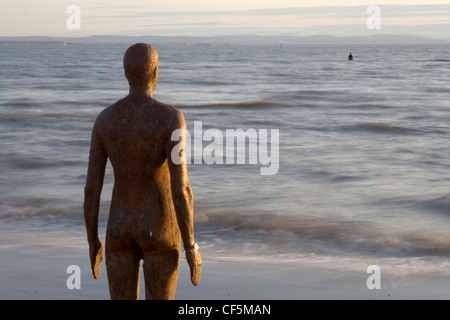 Eine von Antony Gormley Ironmen starrt in Richtung der Wirral und den walisischen Hügeln. Es gibt hundert Zahlen insgesamt und Sie Stockfoto