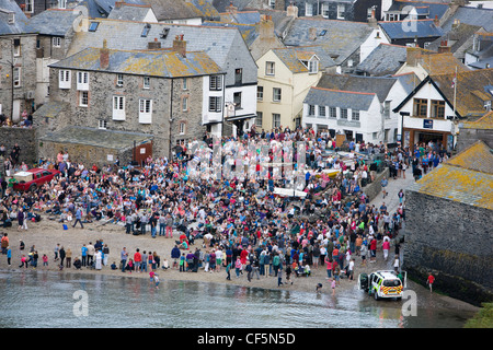 Menschenmassen in Port Isaac, Cornwall, beobachten die Fischer Freunde Shanty Sänger am Strand Stockfoto