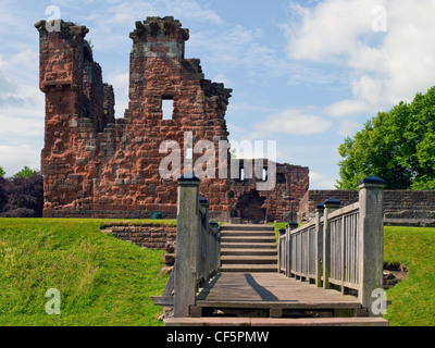 Ein Holzsteg über einen Graben führt zu den Ruinen von Penrith Castle, einmal eine königliche Festung für Richard, Duke of Gloucester Stockfoto