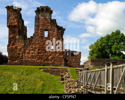 Ein Holzsteg über einen Graben führt zu den Ruinen von Penrith Castle, einmal eine königliche Festung für Richard, Duke of Gloucester Stockfoto