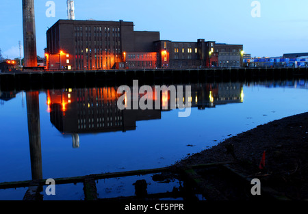 Blick über das Wasser zu den beleuchteten Docks aus Kork. Stockfoto