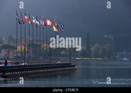 Flaggen entlang der Hafenmauer in Bardolino, Gardasee, Italien Stockfoto