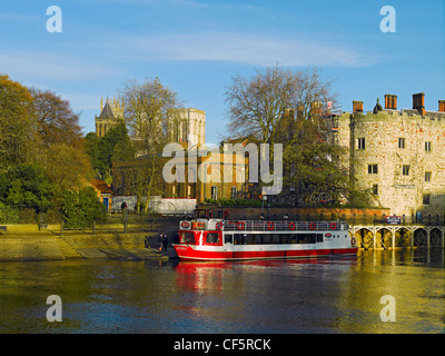 Ausflugsschiff vor Anker am Fluss Ouse im Lendal Tower mit York Minster im Hintergrund. Stockfoto