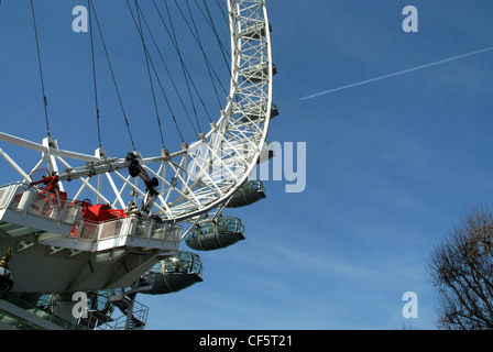Blick hinauf in Richtung Pods auf das London Eye und die Kondensstreifen aus einem Flugzeug über Kopf vorbei. Stockfoto