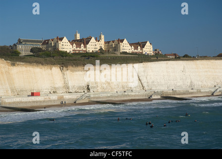 Surfer im Meer unter weißen Kreidefelsen in der Nähe von Brighton Marina. Stockfoto