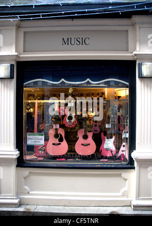 Ein Schaufenster von einem Musikgeschäft mit einer Reihe von rosa farbigen Gitarren in Kingston upon Thames. Stockfoto