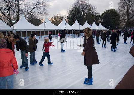 Familienspaß auf der Eisbahn im Winter-Wunderland im Hyde Park. Stockfoto