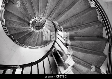 Eine Person absteigend die Wendeltreppe im Inneren des Denkmals in der City of London. Das Denkmal ist eine kolossale dorische Säule 61 mete Stockfoto