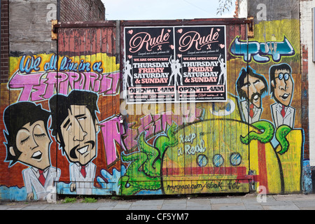 Grafitti besprüht über ein Tor mit den Beatles. Stockfoto