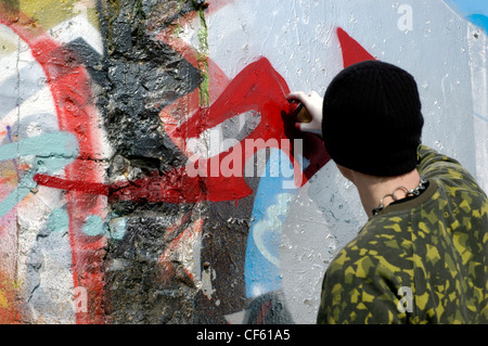 Ein junger Mann sprüht Graffiti an der Wand in Brighton. Bereiche der Südküste Stadt wurde beiseite für Graffiti-Künstler in einem Stockfoto