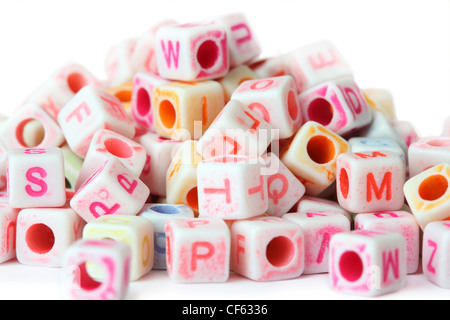 viele kleine Würfel Perlen mit Buchstaben, isoliert auf weiss Stockfoto