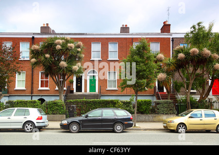 Autos parken in der Nähe von zweistöckigen rote Backsteinhaus auf Street in Dublin, Irland Stockfoto